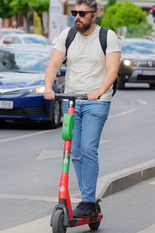 Bearded man running on an electric scooter
